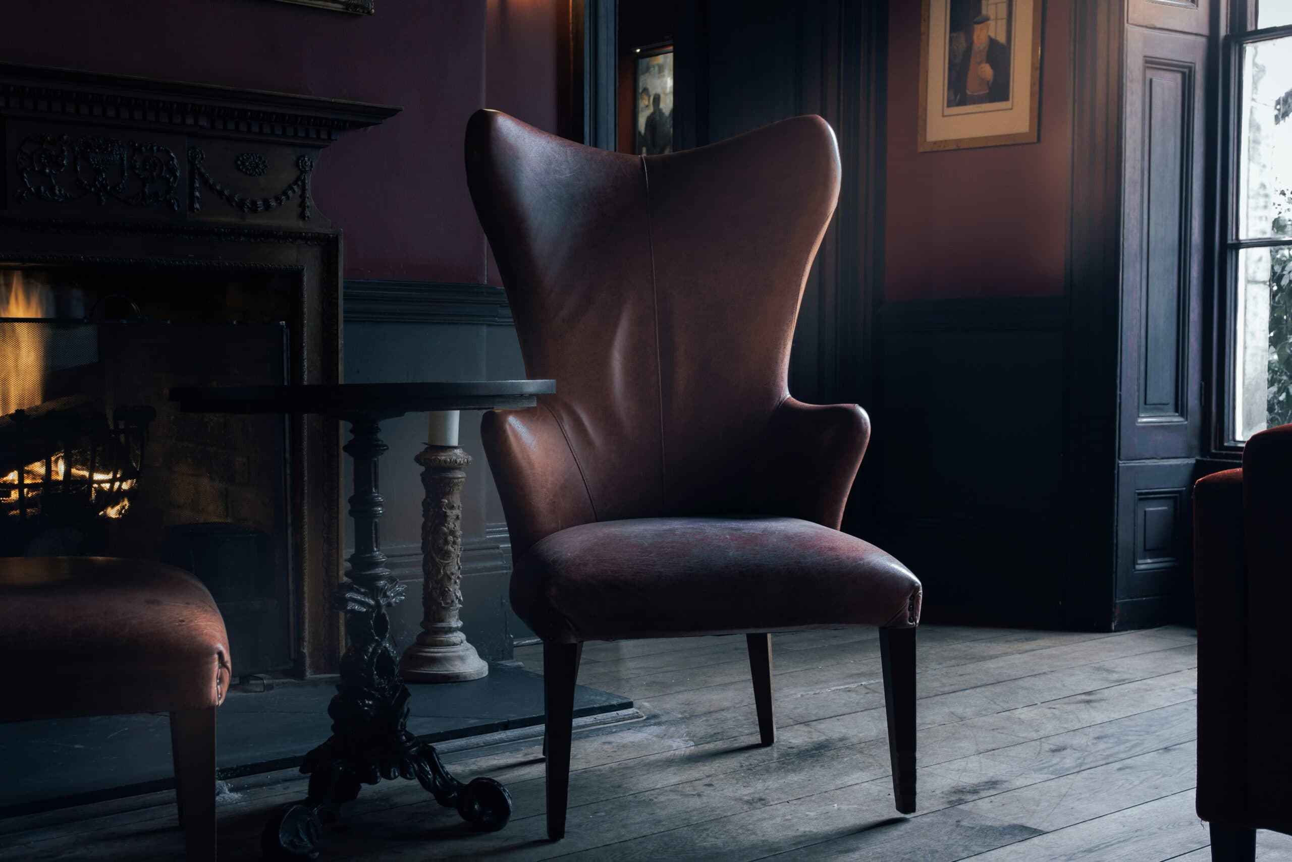 Brown chair in dimly lit study.